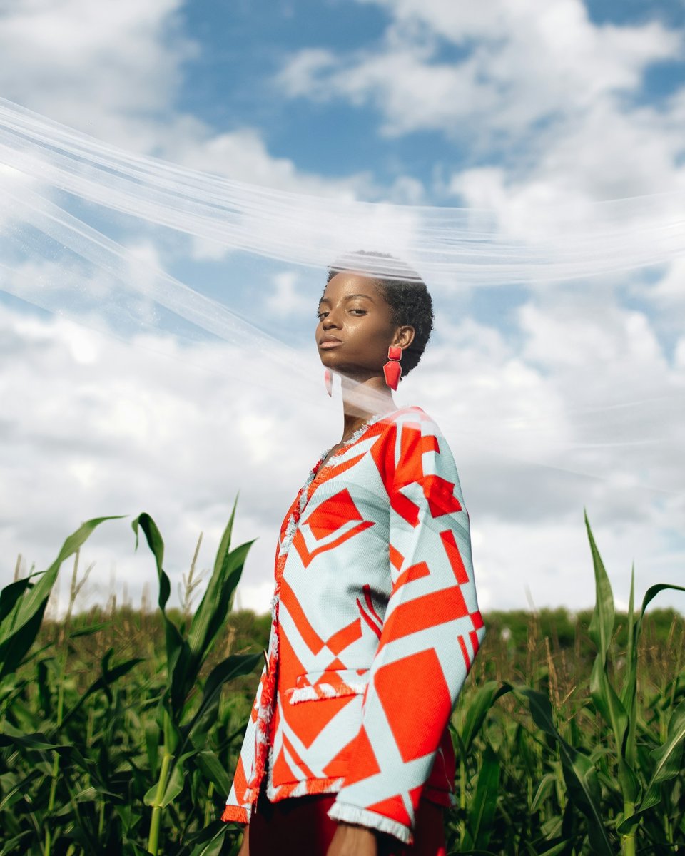 A woman in a floral shirt in a green field
