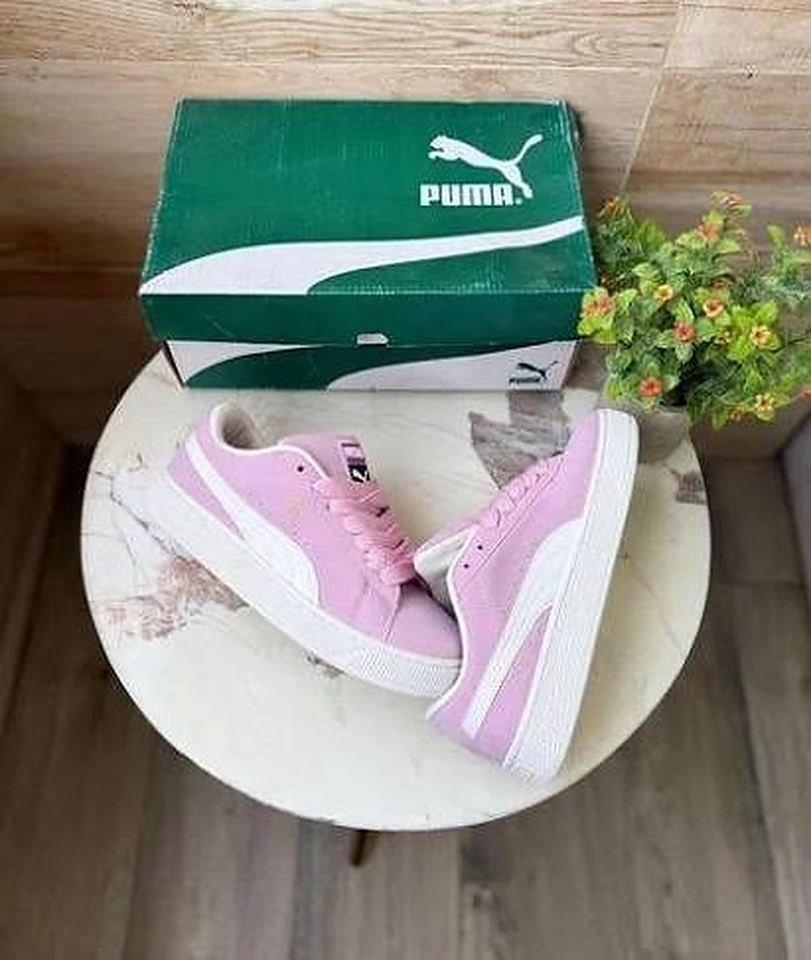 Pink suede sneakers beside their box