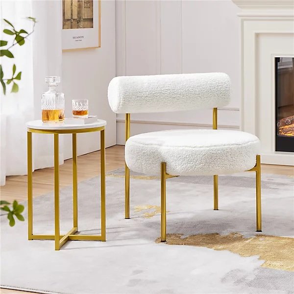 A white boucle chair with gold legs