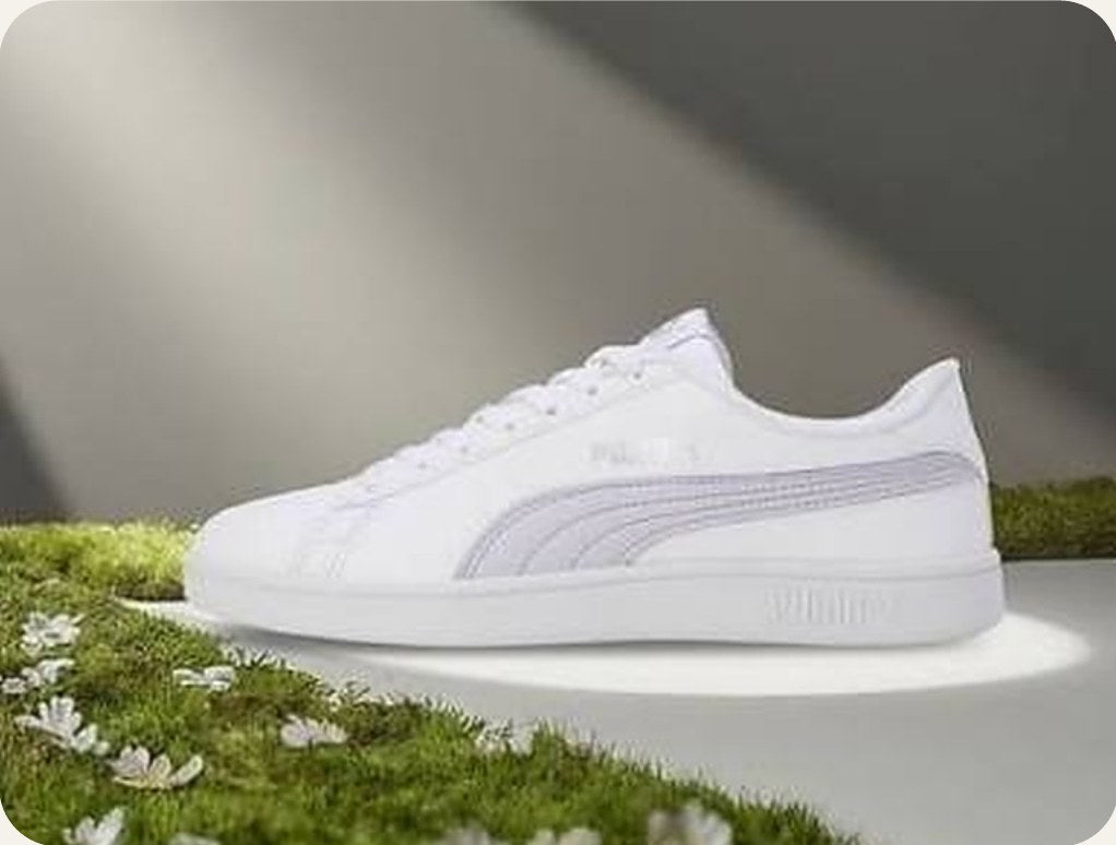 A white PUMA sneaker on grass
